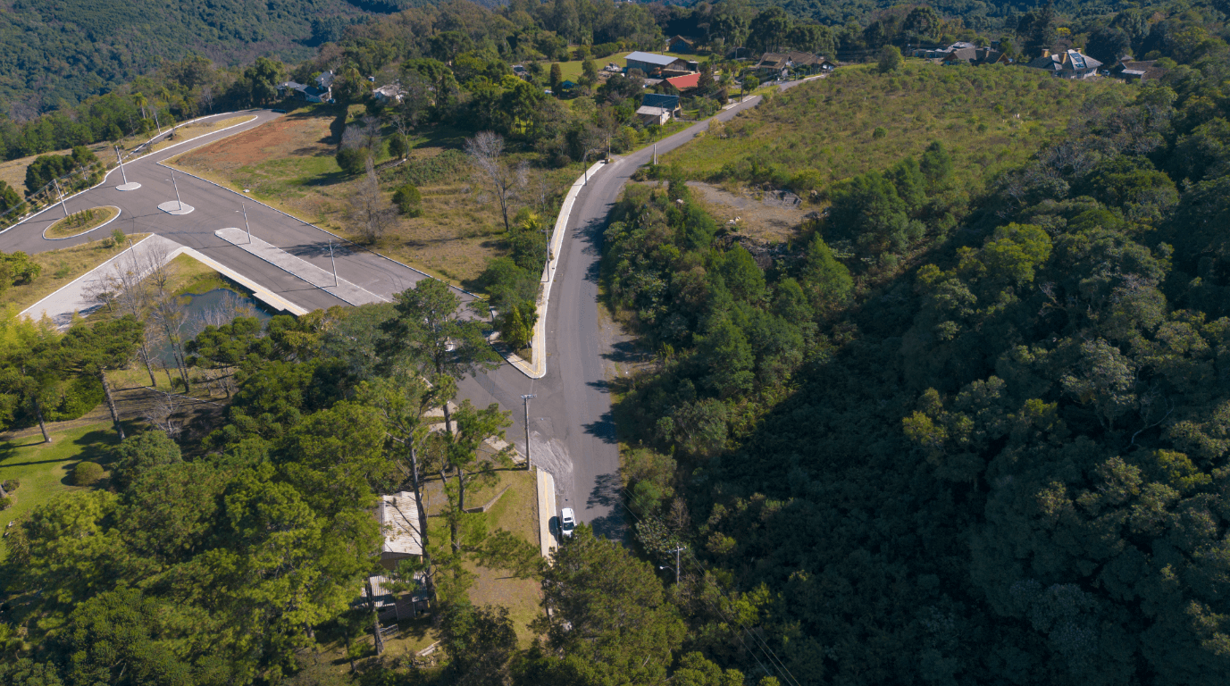 Life & Health — vista aérea da rotatória de acesso ao empreendimento, mostrando a interseção viária, lotes e entorno com vegetação em Gramado, RS